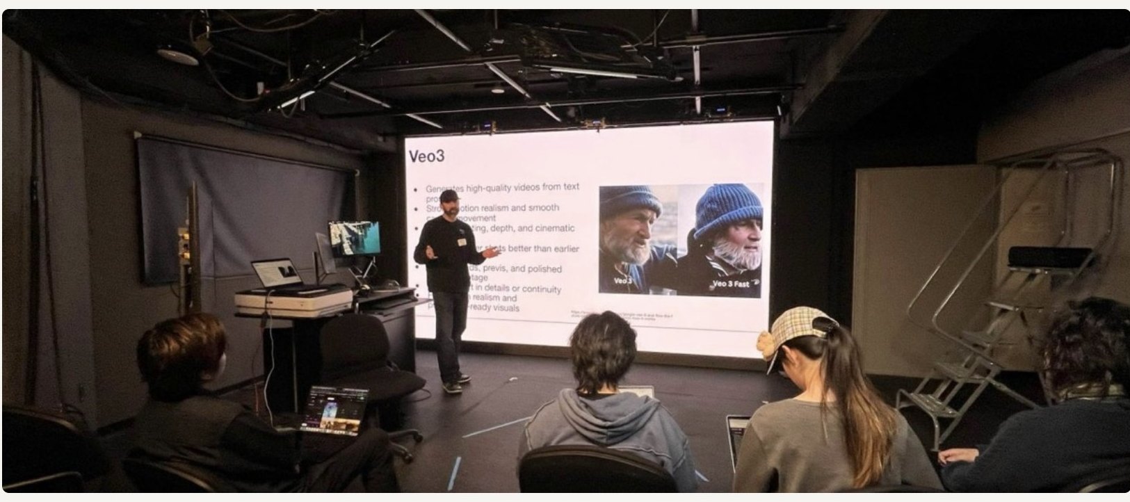 Erich standing in front of the big white screen, a Veo3 slide on it, running a workshop in a studio.